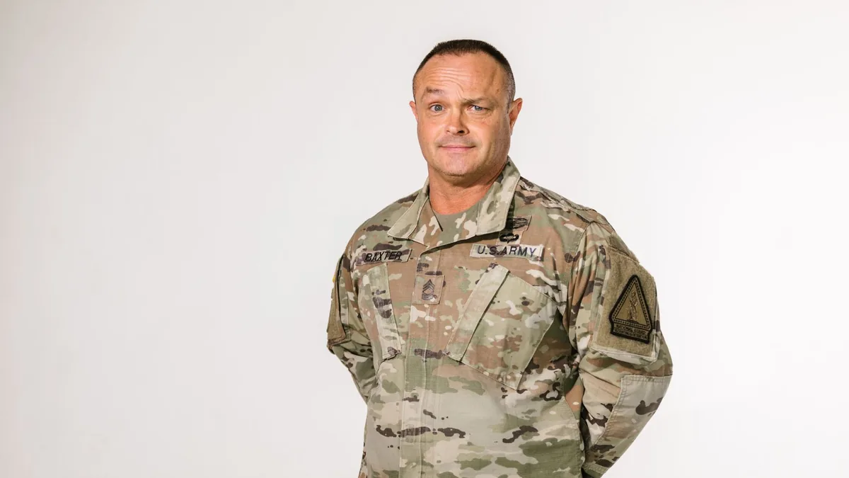 Portrait of a proud American military veteran standing in uniform on a white background.